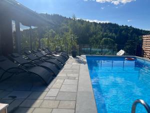 a swimming pool with a bunch of chairs next to it at Breńskie Tarasy in Brenna