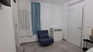 a bedroom with a blue chair and a dresser at Case Vacanze Angolo Sul Mare in Nicotera Marina