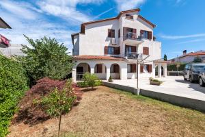 a large white house with a yard at Guesthouse Santin in Rovinj