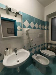 a bathroom with a sink and a toilet at Villa Rosa Rooms in Ischia Town