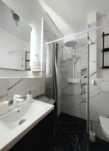 a white bathroom with a sink and a shower at Apartman"Petra" in Krk