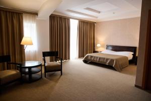 a hotel room with a bed and a table and chair at Lavina Park Hotel in Dnipro +13 photos