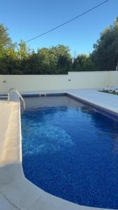 a swimming pool with blue water next to a white wall at Swimming pool apartment in Budva