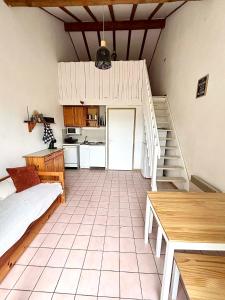 a living room with a staircase and a kitchen at Maison proche vallon pont d arc in Salavas