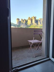 a chair sitting in front of a window at Meteora Gold and Glass in Kalabaka +46 photos