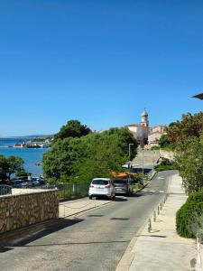 a white car parked on a street next to the water at Apartman"Petra" in Krk