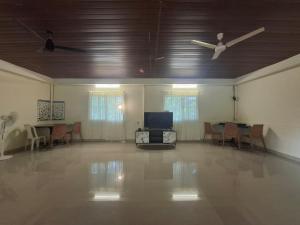 a room with a ceiling fan and a table and chairs at The Beach House in Cochin
