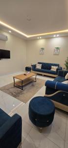 a living room with blue couches and a coffee table at دان إقامة هادئة in Medina
