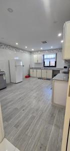 a large kitchen with white appliances and a wooden floor at دان إقامة هادئة in Medina +4 photos