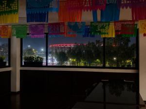 a window with a view of a city at night at Mariachi House in Mexico City +9 photos