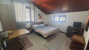 a bedroom with a bed and a desk and window at Vojinovic Apartments in Budva