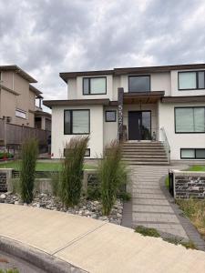a white house with a staircase in front of it at Cozy home in Burnaby