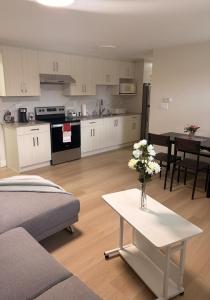 a kitchen and living room with a vase of flowers on a table at Cozy home in Burnaby
