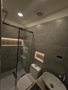 a bathroom with a toilet and a shower and a sink at Villa Yasmin in Prado