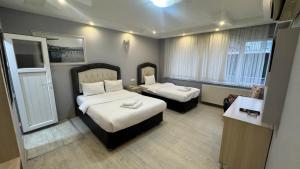 a hotel room with two beds and a table at Pera City Otel in Samsun