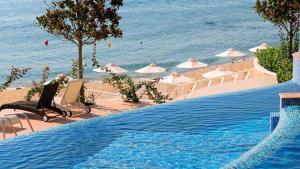 a large swimming pool next to the beach with umbrellas at Luxurious and panoramic apartments at the beach in La Mer complex in Golden Sands
