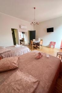 a bedroom with two beds and a dining room at Les Suites du Quai in Montmélian