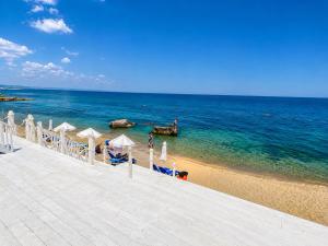 a beach with chairs and umbrellas and the ocean at Luxurious and panoramic apartments at the beach in La Mer complex in Golden Sands