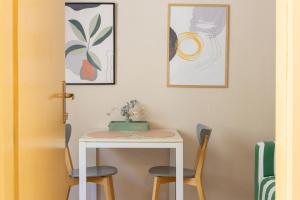 a table and chairs in a room with paintings at PINE&SHINE Waterfront in Podgora +17 photos