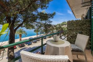 a balcony with a table and chairs and a view of the ocean at PINE&SHINE Waterfront in Podgora