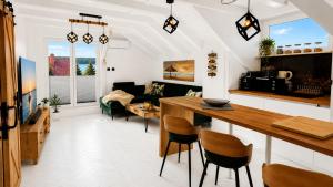 a kitchen and living room with a table and chairs at CHARZYKOWSKIE TARASY in Charzykowy