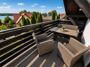 a patio with two chairs and a table on a balcony at CHARZYKOWSKIE TARASY in Charzykowy
