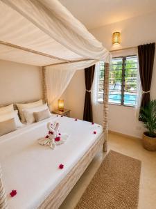 a bedroom with a white bed with a bunny on it at Blue Diamond Villa Watamu in Watamu +29 photos