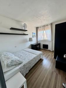a bedroom with a bed and a desk and a window at Appartement Port Marianne Montpellier in Montpellier