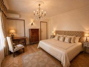 a bedroom with a large bed and a chandelier at Villa Daurus in Vallauris +25 photos