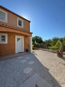 a house with a gravel driveway in front of it at Villa Mathilde - 3 Chambres - Jacuzzi in Béziers