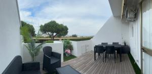 a balcony with a table and chairs on a patio at La Terrazza sul Delta in Porto Levante +5 photos