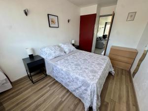 a bedroom with a bed and a table and a mirror at Appartement Port Marianne Montpellier in Montpellier