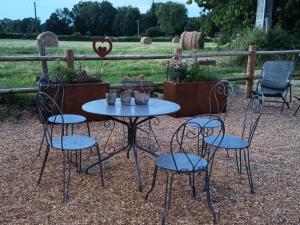 a table and chairs with flowers and a fence at La maison de July in La Roë +5 photos