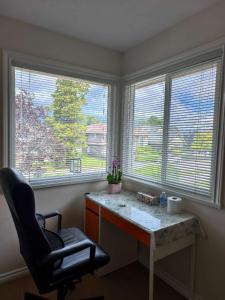 a desk in a room with two windows and a chair at Cozy Room With King-sized Bed in Richmond