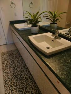 a bathroom with two sinks and two potted plants at Cozy Room With King-sized Bed in Richmond