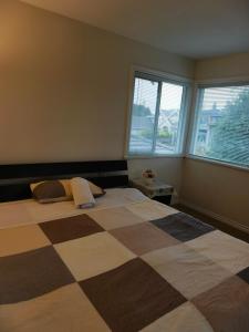 a bedroom with a large bed and two windows at Cozy Room With King-sized Bed in Richmond