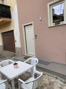 a white table and chairs in front of a building at Da Mina Rooms & Apartament in Flumeri