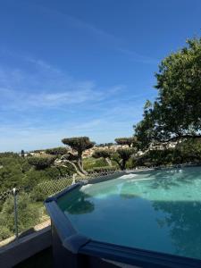 a swimming pool with a view of a garden at Villa Mathilde - 3 Chambres - Jacuzzi in Béziers