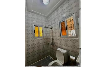 a bathroom with a toilet and a shower at Résidence ADJOBIA - Grâce divine YAMOUSSOUKRO in Yamoussoukro +7 photos