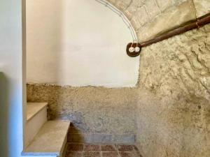 a bathroom with a stone wall and stairs in a room at Pedra e Lozzu in Sedini +8 photos