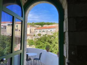 an arched window with a table and chairs and a view at Pedra e Lozzu in Sedini