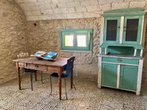 a table and a cabinet in a room at Pedra e Lozzu in Sedini