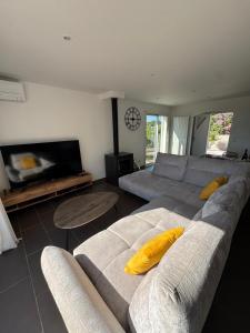 a living room with a couch and a tv at Villa Mathilde - 3 Chambres - Jacuzzi in Béziers