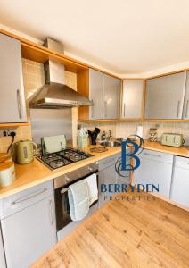 a kitchen with white cabinets and a stove top oven at Restmore House in Inverugie Mill