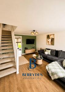 a living room with a couch and a staircase at Restmore House in Inverugie Mill