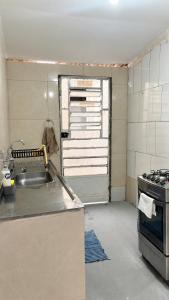 a kitchen with a sink and a stove at Casa a 8 minutos do Parque do Povo - Campina Grande PB in Campina Grande