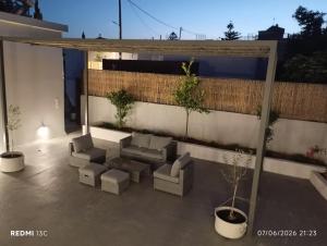 a patio with couches and chairs on a building at MAGIA's HOUSE in Karistos