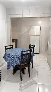 a table and chairs in a kitchen with a refrigerator at Casa a 8 minutos do Parque do Povo - Campina Grande PB in Campina Grande +2 photos