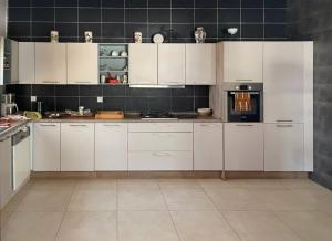 a large white kitchen with white cabinets and appliances at Paradise in Yène
