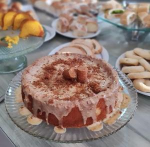 a cake on a plate on a table with other desserts at Hotel Mohallem in Passos +19 photos